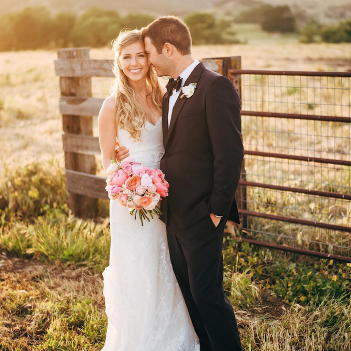 Happy bride and groom in the field of a farm.
