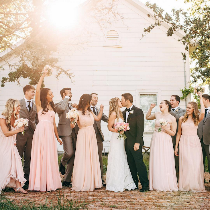 Happy wedding party celebrating outside.