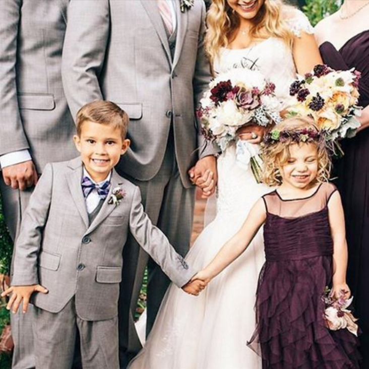 Ring boy and flower girl holding hands in front of the wedding party.